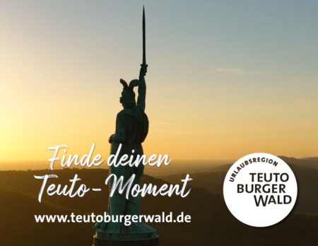 Hermannsdenkmal bei Sonnenuntergang, Schrift zur Website & "Finde deinen Teuto-Moment" mit Logo der Urlaubsregion Teutoburger Wald